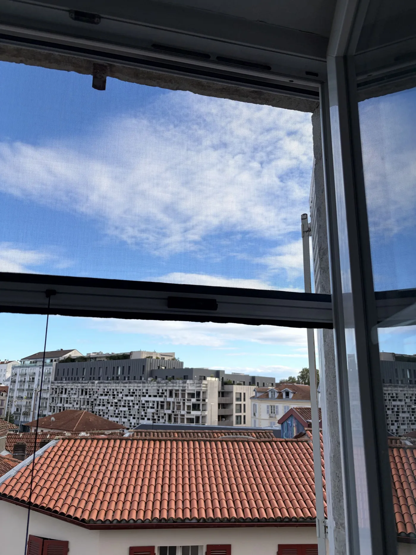 Moustiquaire installée sur une fenêtre à Bayonne, vue depuis l’intérieur