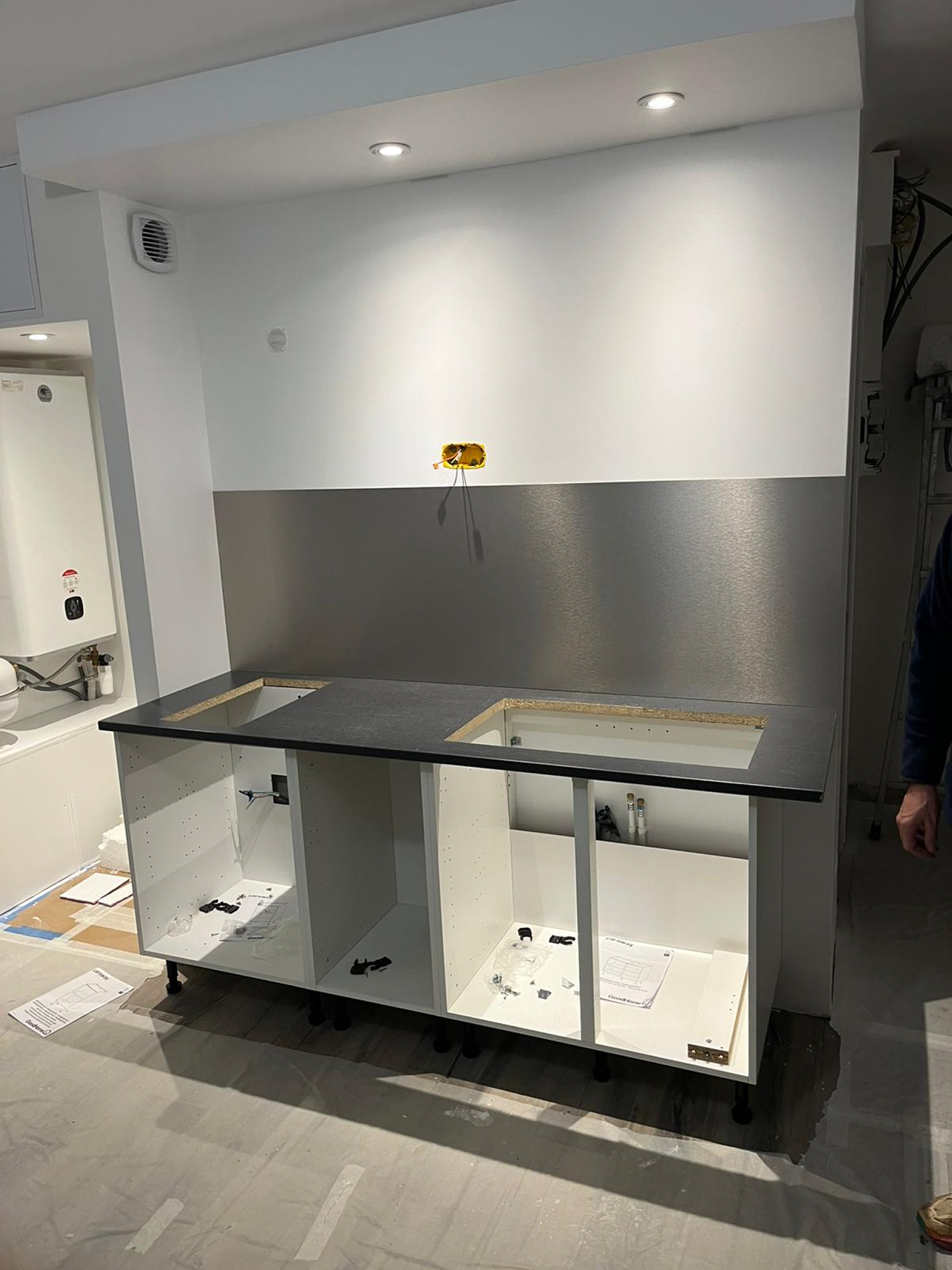 Cuisine compacte en cours de montage avec meubles bas ouverts et plan de travail découpé