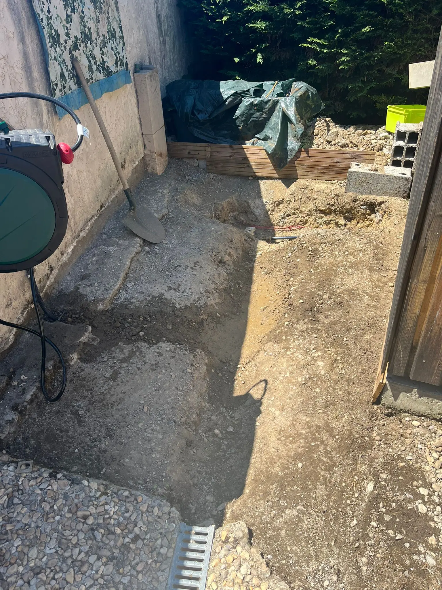Passage extérieur avant travaux avec sol décaissé et préparation de l’évacuation